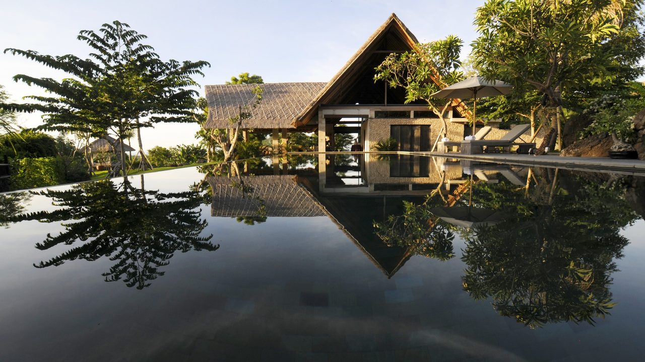Photo d’origine, une villa au bord d’une piscine à débordement, en plein jour
